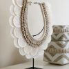 shell necklace on stand