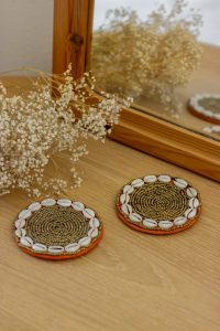 Beaded coaster with cowrie shells